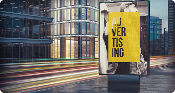 Digital billboard displaying yellow 'ADVERTISING' poster in urban setting with modern glass buildings and light trails from passing traffic